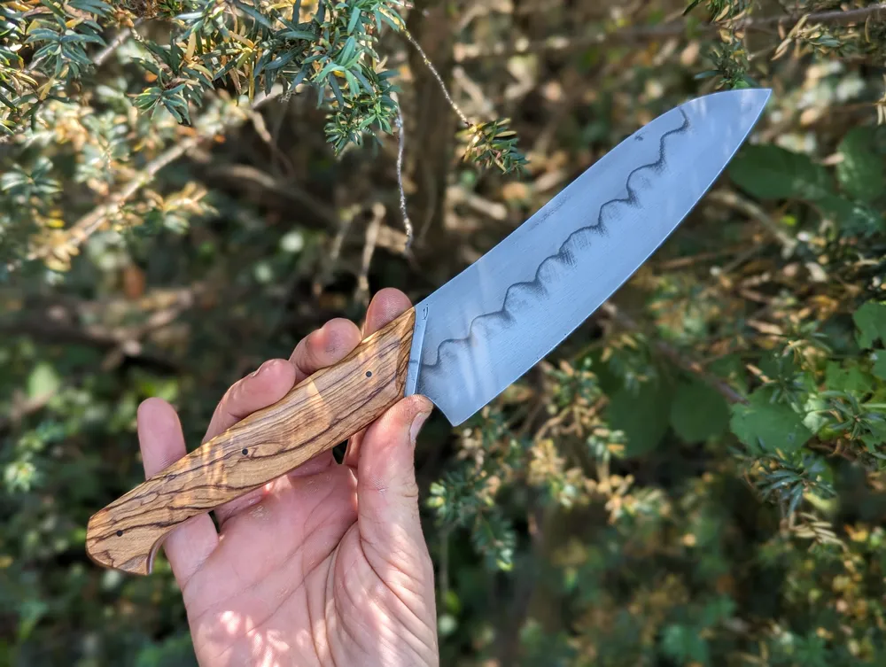 Couteau artisanal Grand Bonap manche olivier présenté en main – Atelier sous l’éclipse